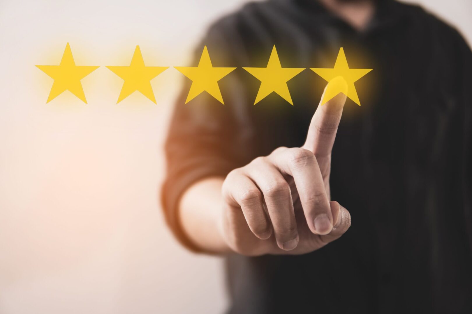 A person pointing to five stars on a screen.